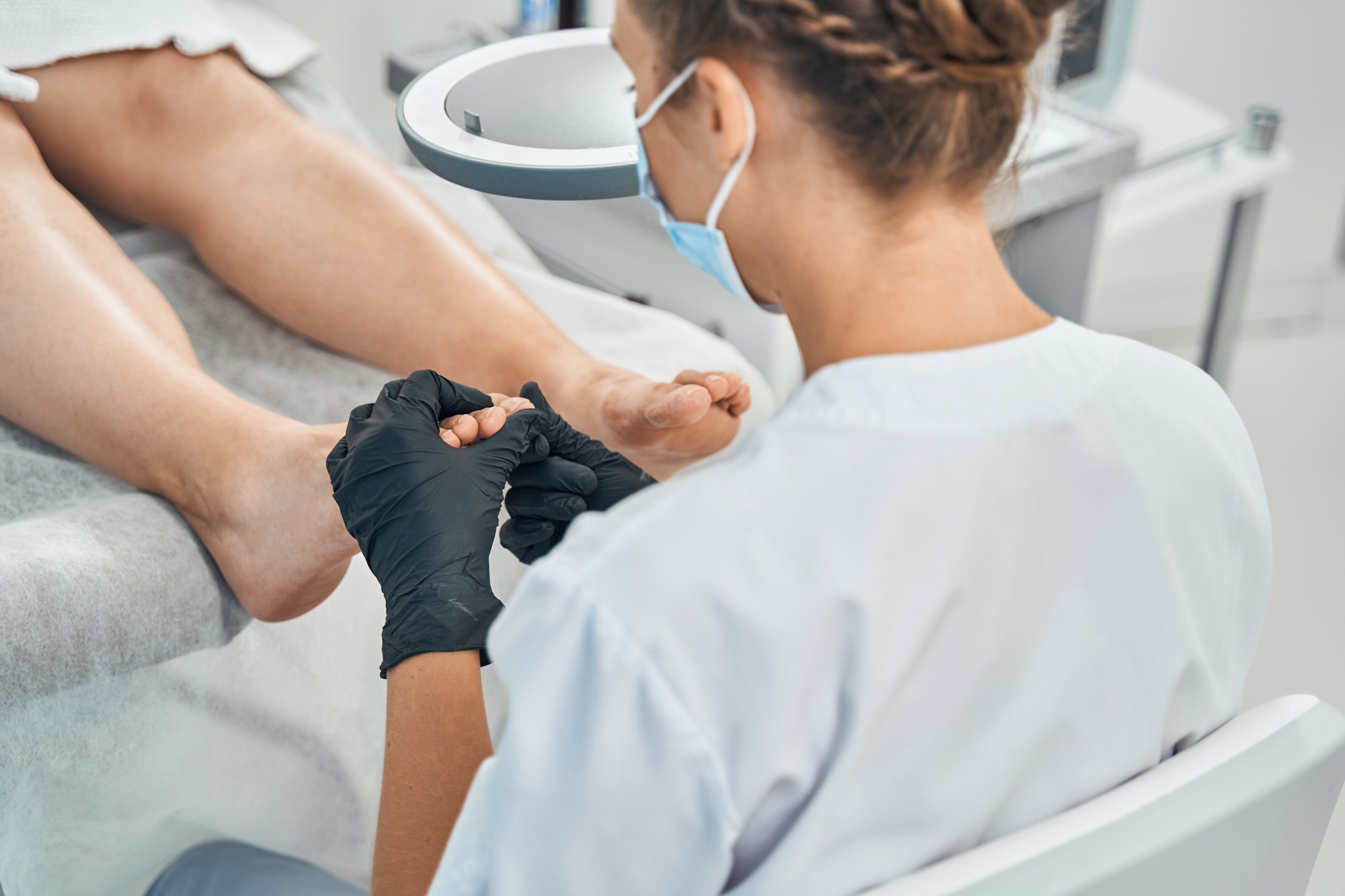Close up of specialist massaging toes before procedure
